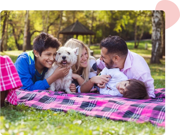 A group of people laying on the ground with a dog.