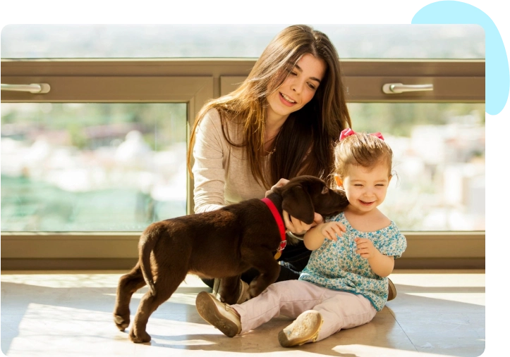 A woman and child with a dog on the floor.