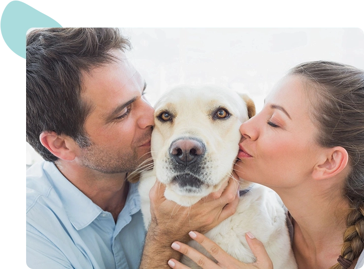 A man and woman kissing their dog.