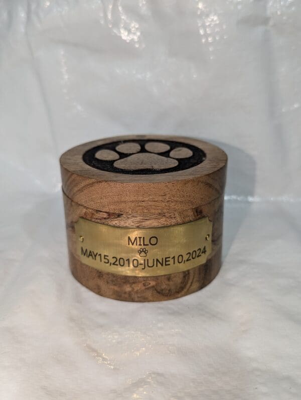 A wooden box with a paw print on the lid.